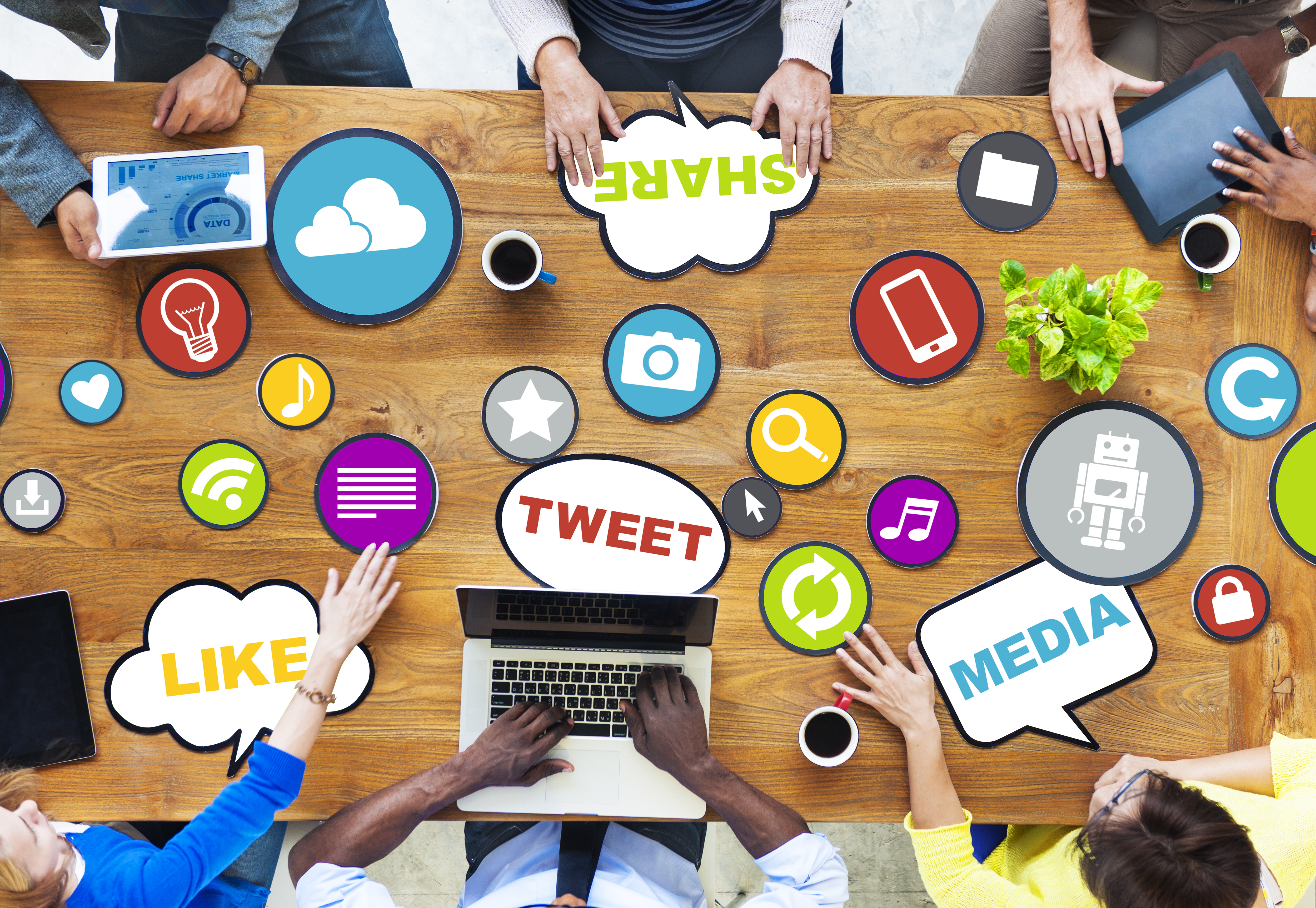 A topdown view of a six-person conference where the table is covered with social media icons.